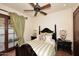 This bedroom features a four post bed, ceiling fan, and french door exit to the yard at 2041 W Hemlock Way, Chandler, AZ 85248