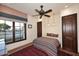This bedroom has a ceiling fan, area rug, and large window looking out to the neighborhood at 2041 W Hemlock Way, Chandler, AZ 85248