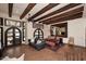 Spacious dining room featuring wooden beams, terracotta flooring, large mirrors, and stylish furniture at 2041 W Hemlock Way, Chandler, AZ 85248