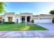Well-manicured front lawn and exterior elevation of a home with a three-car garage at 2041 W Hemlock Way, Chandler, AZ 85248