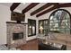 Living room featuring exposed beams, a fireplace, large windows, and comfortable seating at 2041 W Hemlock Way, Chandler, AZ 85248