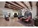 Open-concept living room with wood beam ceilings, tiled floors, and staircase to additional rooms at 2041 W Hemlock Way, Chandler, AZ 85248