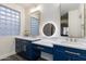 Stylish bathroom featuring navy blue cabinets, white quartz countertop, and modern, gold-tone hardware at 20713 N 91St Dr, Peoria, AZ 85382