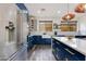 Bright kitchen boasts blue lower cabinets, stainless steel appliances, and a farmhouse sink at 20713 N 91St Dr, Peoria, AZ 85382