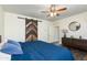 Bedroom featuring barn door accent, dresser and round mirror with blue bedding at 20713 N 91St Dr, Peoria, AZ 85382