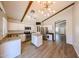 Open kitchen with stainless steel appliances, a kitchen island, white cabinets, and wood laminate flooring at 20802 N 7Th Pl, Phoenix, AZ 85024
