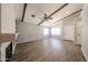 Spacious living room with modern wood laminate flooring, ceiling fan, exposed ceiling beams, and a fireplace at 20802 N 7Th Pl, Phoenix, AZ 85024