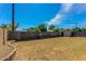 Large backyard with wood fence featuring a mix of grass and weeds, with some landscaping along the fence at 2213 E Campbell Ave, Phoenix, AZ 85016