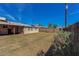 Large backyard has green grass, tall wood fence, covered patio and mature shade trees at 2213 E Campbell Ave, Phoenix, AZ 85016