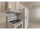 White kitchen has a refrigerator and electric stove; next to a large dining area at 2213 E Campbell Ave, Phoenix, AZ 85016