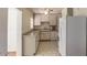Efficient kitchen includes tile flooring, white cabinets and appliances, and great lighting at 2213 E Campbell Ave, Phoenix, AZ 85016