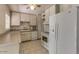 Efficient kitchen features white cabinets and appliances, tile floor, and built in microwave at 2213 E Campbell Ave, Phoenix, AZ 85016