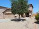 Two-story home featuring a two-car garage, desert landscaping, and a tree in the front yard at 2434 E San Manuel Rd, San Tan Valley, AZ 85143