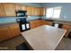 Bright kitchen features wood cabinets, laminate countertops, black appliances, and a large window at 2434 E San Manuel Rd, San Tan Valley, AZ 85143
