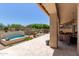 Backyard oasis featuring a soothing water feature, stone pavers, and a covered patio for relaxation at 27953 N 111Th Way, Scottsdale, AZ 85262
