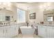 Well-lit bathroom with a standalone soaking tub, dual vanities and granite countertops at 27953 N 111Th Way, Scottsdale, AZ 85262