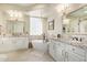 Luxurious bathroom featuring a soaking tub, dual vanities, and stylish lighting fixtures at 27953 N 111Th Way, Scottsdale, AZ 85262