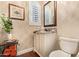 Charming powder room with designer wallpaper, granite countertop, and a framed mirror at 27953 N 111Th Way, Scottsdale, AZ 85262