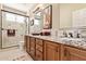 Bright bathroom featuring dual sinks, granite countertops, and a tiled shower with glass door at 27953 N 111Th Way, Scottsdale, AZ 85262