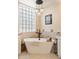 Elegant bathtub with a modern faucet, set against a backdrop of glass block windows at 27953 N 111Th Way, Scottsdale, AZ 85262