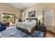 Stylish bedroom with a comfortable bed, an eye-catching blue rug, and access to the backyard at 27953 N 111Th Way, Scottsdale, AZ 85262