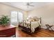 Cozy bedroom with decorative iron bed, hardwood floors, and shuttered window at 27953 N 111Th Way, Scottsdale, AZ 85262