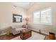Comfortable bedroom featuring hardwood floors, a tufted couch, and plantation shutters for natural light at 27953 N 111Th Way, Scottsdale, AZ 85262
