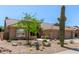 Charming single-story home with desert landscaping featuring cacti, trees, and a rock garden at 27953 N 111Th Way, Scottsdale, AZ 85262