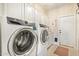 Functional laundry room featuring white cabinets and modern washer and dryer units at 27953 N 111Th Way, Scottsdale, AZ 85262