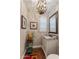 Charming powder room featuring decorative wallpaper, a marble countertop vanity, and unique chandelier at 27953 N 111Th Way, Scottsdale, AZ 85262