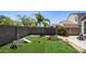A backyard with a block wall, desert landscaping, and a section of artificial turf at 33013 N Ash Tree Ln, San Tan Valley, AZ 85144