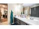 Bathroom featuring a double sink vanity, alongside a view to the walk in closet at 33013 N Ash Tree Ln, San Tan Valley, AZ 85144