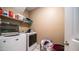 Functional laundry room with a washer, dryer, and shelves for storage at 33013 N Ash Tree Ln, San Tan Valley, AZ 85144