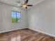 Bright bedroom with hardwood floors, a ceiling fan, and a window with a backyard view at 3809 E Lynx Pl, Chandler, AZ 85249