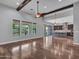 Open-concept living room with hardwood floors, beamed ceiling, and kitchen access, perfect for modern living at 3809 E Lynx Pl, Chandler, AZ 85249