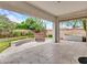 A stylish covered patio features elegant stone flooring, a stone-clad fountain, and serene views of the landscaped yard at 3809 E Lynx Pl, Chandler, AZ 85249