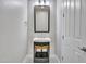 Stylish powder room featuring a modern vanity, decorative mirror, and tiled floor at 3809 E Lynx Pl, Chandler, AZ 85249