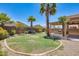 This backyard features a well-manicured lawn, a brick wall, and palm trees at 38125 W Santa Clara Ave, Maricopa, AZ 85138