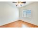 A cozy bedroom with wood floors, a ceiling fan, and a window with blinds at 38125 W Santa Clara Ave, Maricopa, AZ 85138