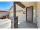 Covered front porch with brick columns, tiled walkway, and view of the three car garage at 38125 W Santa Clara Ave, Maricopa, AZ 85138