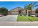 Charming single-story home featuring desert landscaping, green lawn, and a spacious two-car garage at 38125 W Santa Clara Ave, Maricopa, AZ 85138