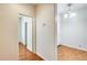 Bright hallway with wood-look flooring and a view into another room through an open door at 38125 W Santa Clara Ave, Maricopa, AZ 85138