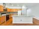 Bright kitchen with granite counters, stainless steel appliances, central island, and warm wood cabinets at 38125 W Santa Clara Ave, Maricopa, AZ 85138