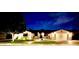Well-lit home exterior at night with green lawn and mature landscaping at 5919 S Newberry Rd, Tempe, AZ 85283