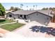 Beautiful single story home boasting a brick driveway, green lawn, and two car garage at 5919 S Newberry Rd, Tempe, AZ 85283