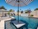 Relaxing pool featuring a water feature with in-pool seating and shaded by large umbrellas at 5919 S Newberry Rd, Tempe, AZ 85283