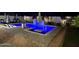 Stunning backyard pool featuring lounge chairs, umbrellas, tiled water feature, and paver surround at night at 5919 S Newberry Rd, Tempe, AZ 85283
