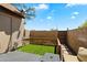 Small fenced backyard with artificial grass, patio, and a gate leading to the back alley at 7977 W Wacker Rd # 220, Peoria, AZ 85381