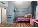 Cozy bedroom with blue walls, wood flooring, a small bed, and ample natural light at 7977 W Wacker Rd # 220, Peoria, AZ 85381
