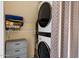 Laundry room with a stacked washer and dryer unit, storage shelves, and neutral decor at 7977 W Wacker Rd # 220, Peoria, AZ 85381